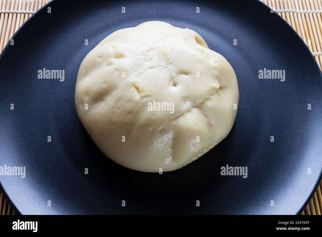 Banh bao al vapore, vietnamita saporito ripieno bun close up, su piatto nero Foto Stock