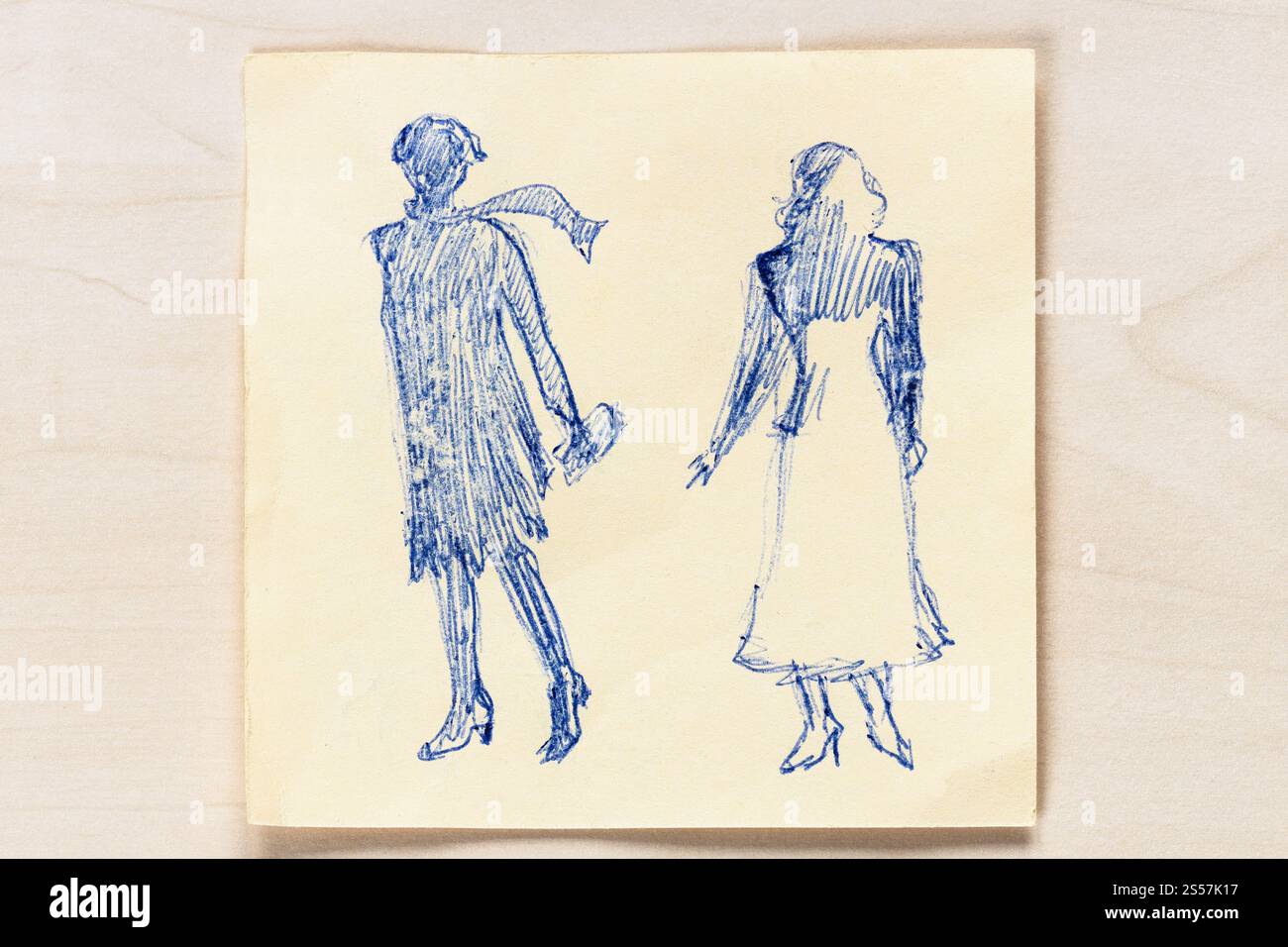 Disegno di una silhouette alla moda di donne degli anni '20 e '30 del XX secolo disegnato a mano con penna a sfera blu su carta da appunti su tavolo marrone chiaro Foto Stock