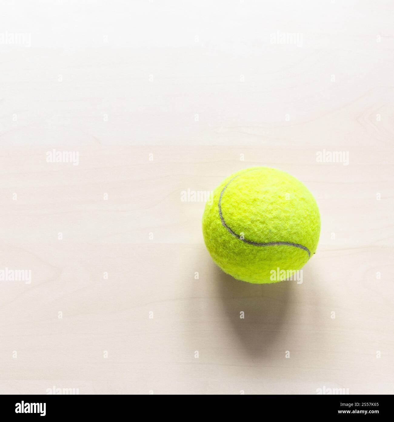 stil vita con palla da tennis su tavolo di legno marrone chiaro con copyspace Foto Stock