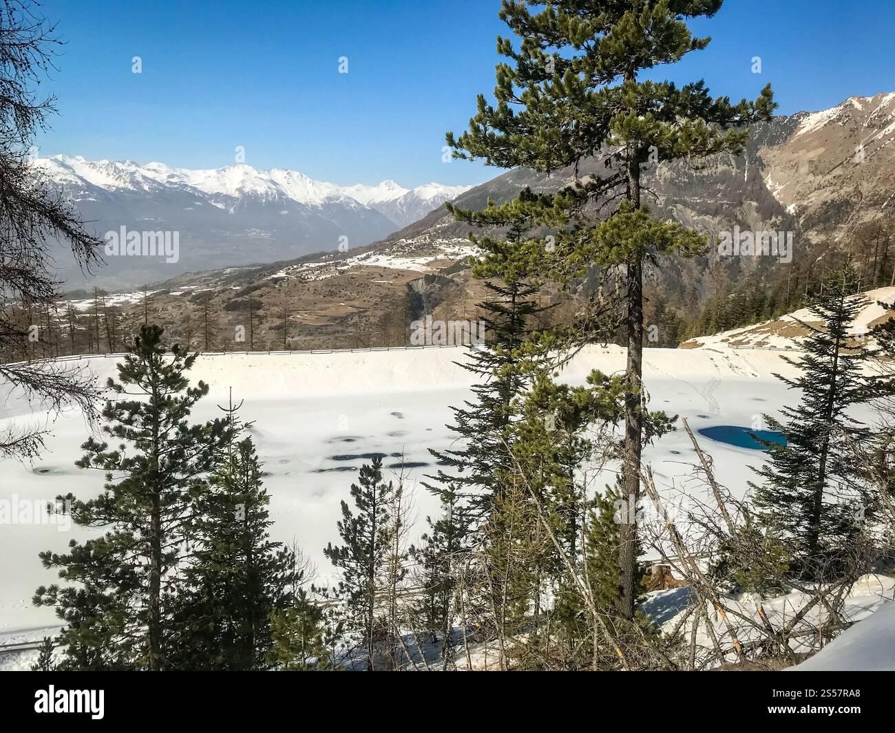 Paesaggio montano sotto la neve in inverno e lago ghiacciato. Il paesaggio di un lago di montagna in inverno Foto Stock