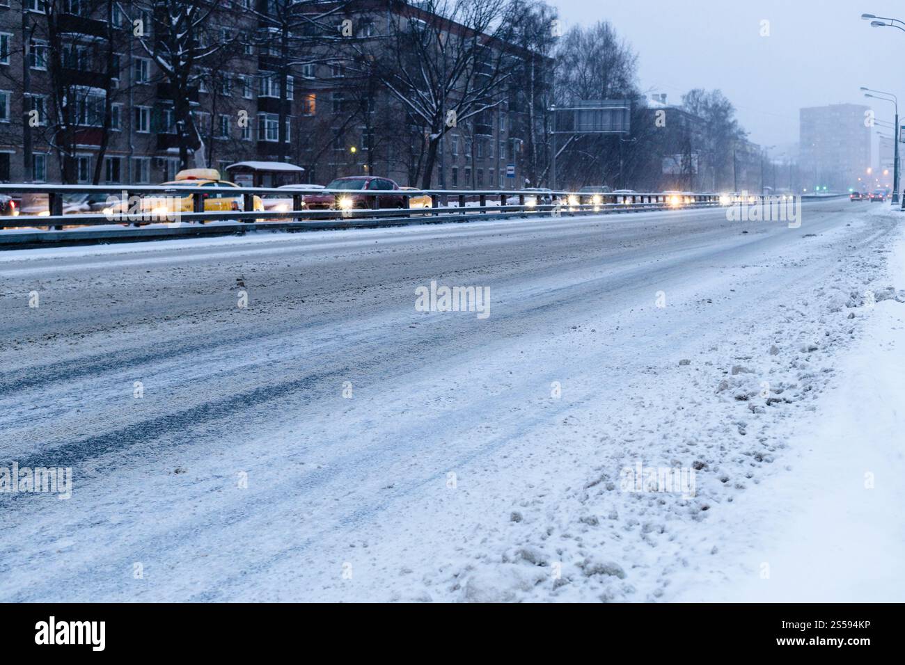 Strada della città vuota coperta di neve in blu crepuscolo invernale nella città di Mosca Foto Stock