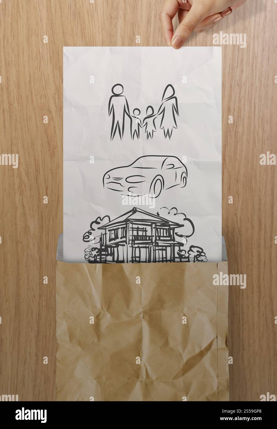 aprire a mano la carta arricciata per mostrare il futuro della famiglia su sfondo in legno come concetto Foto Stock