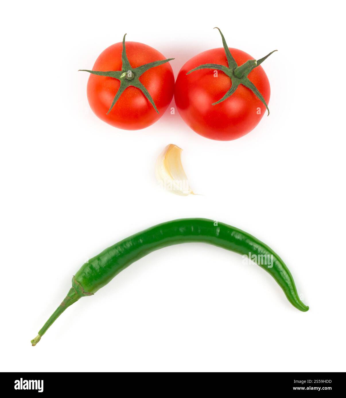 Peperoncino, aglio e tomati isolati su sfondo bianco. Il viso è fatto di verdure Foto Stock