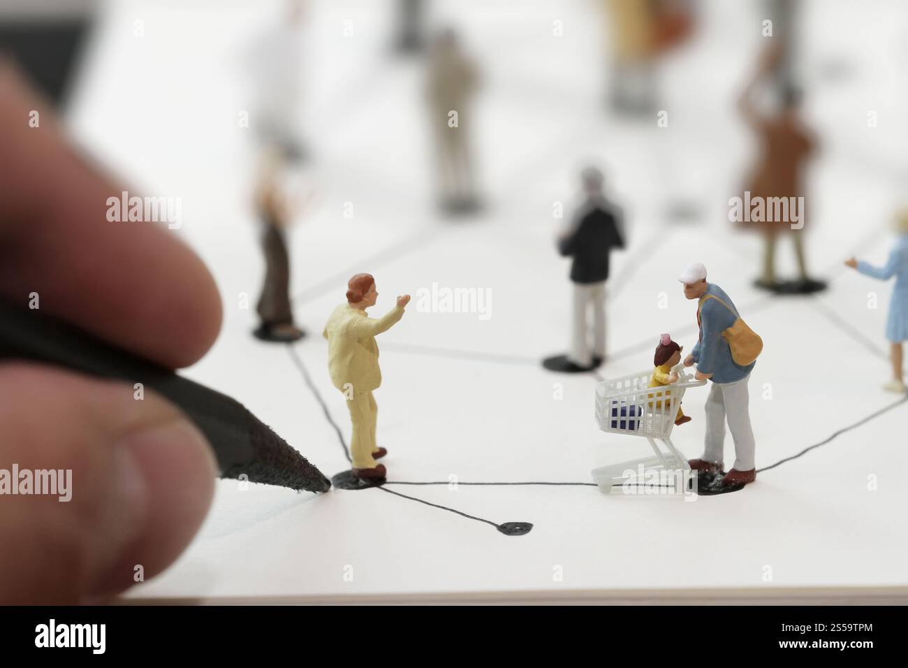 Close up di persone in miniatura con disegno a mano sociale schema di rete sul notebook aperto sulla scrivania di legno come i social media conept Foto Stock