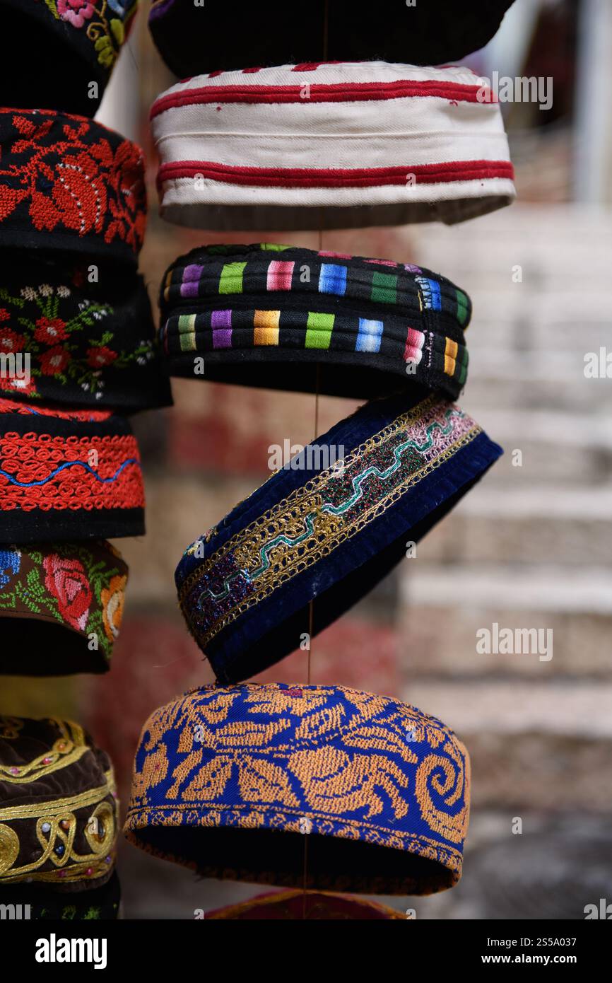 Una varietà di yarmulke o cappellini da teschio ebraici bukhariani colorati e a motivi geometrici in vendita in un quartiere religioso di Gerusalemme. Foto Stock