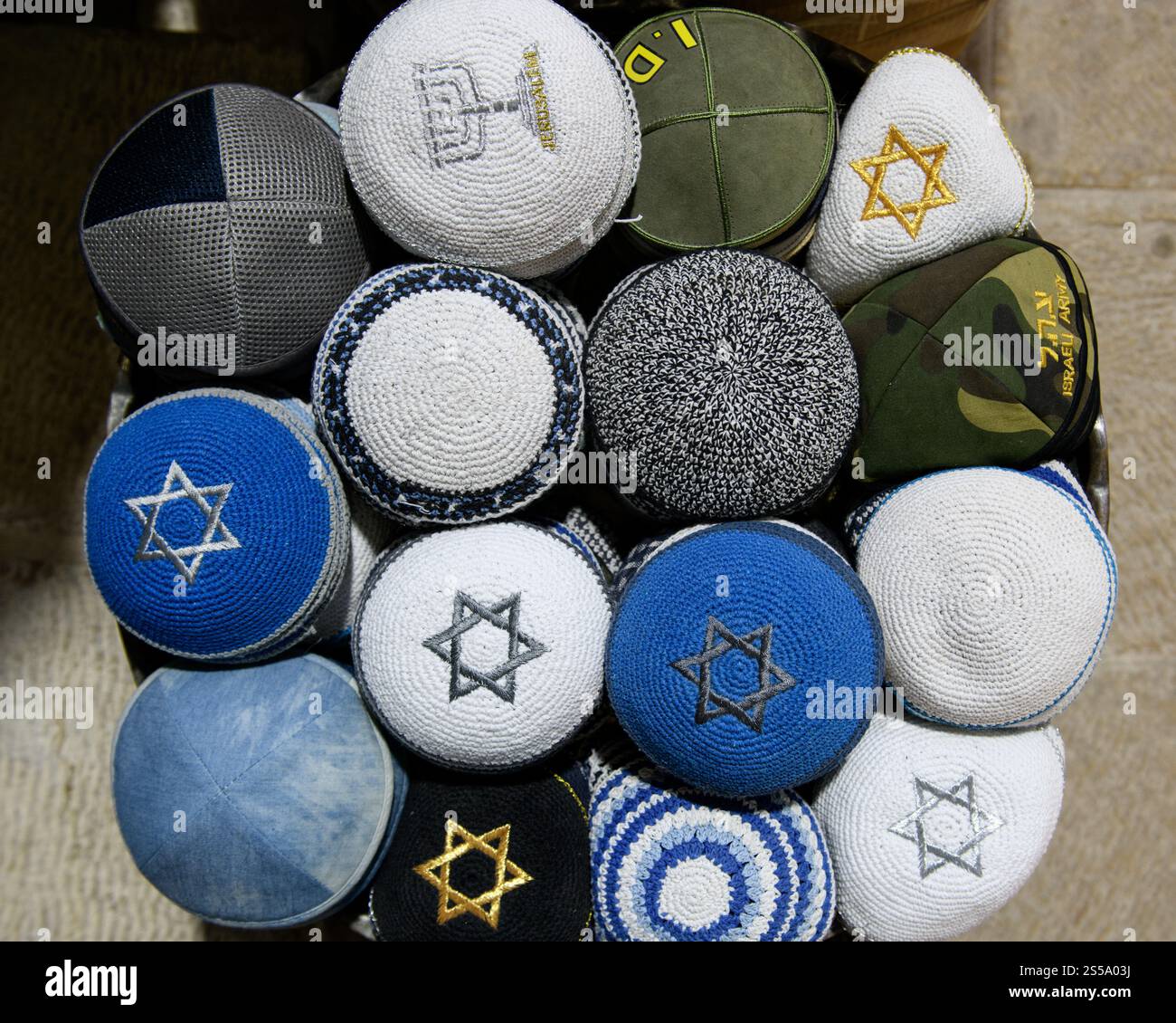 Una varietà di yarmulke o cappellini da teschio ebraici colorati in vendita in un quartiere religioso di Gerusalemme. Foto Stock