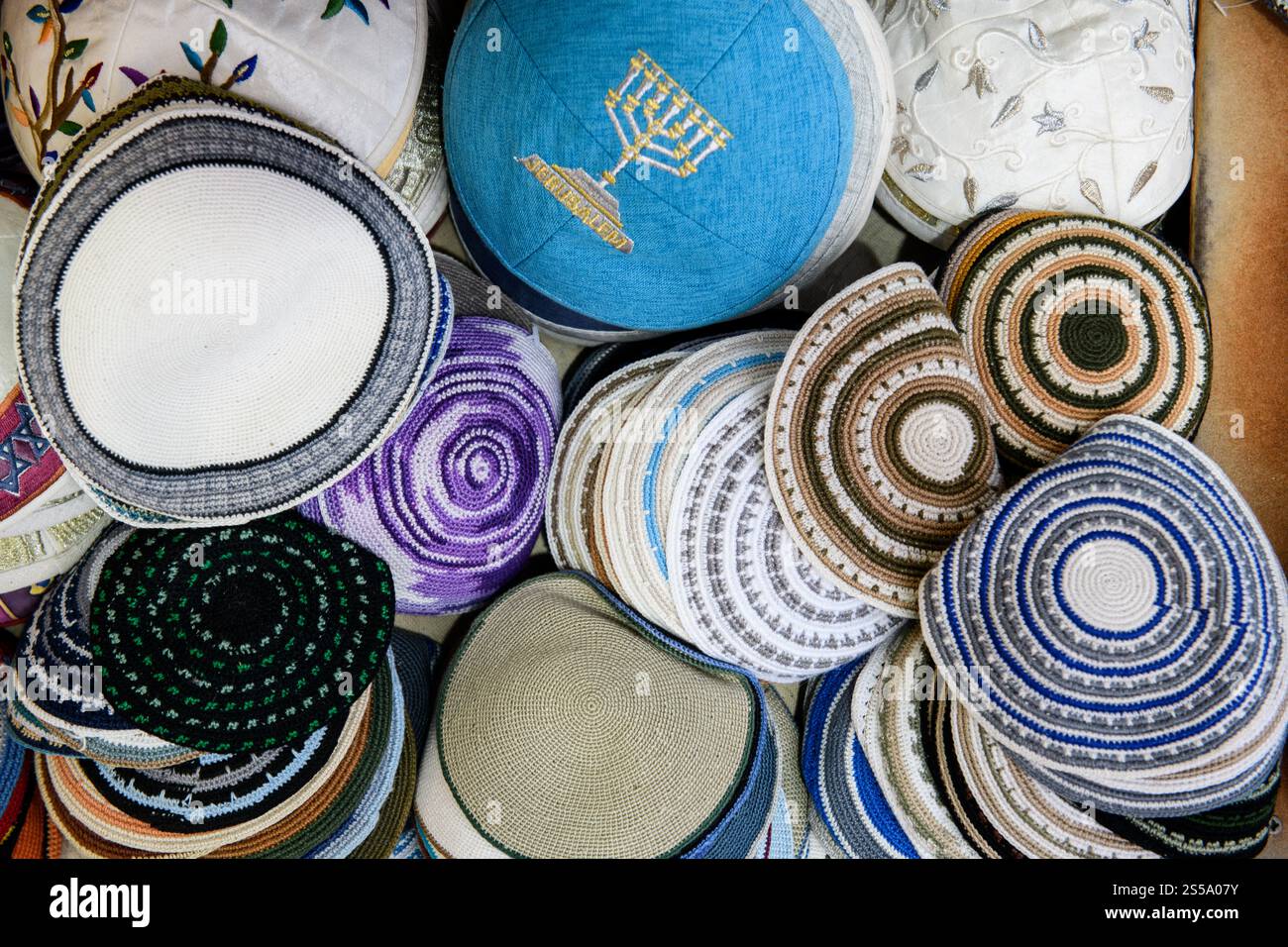 Una varietà di yarmulke o cappellini da teschio ebraici colorati in vendita in un quartiere religioso di Gerusalemme. Foto Stock