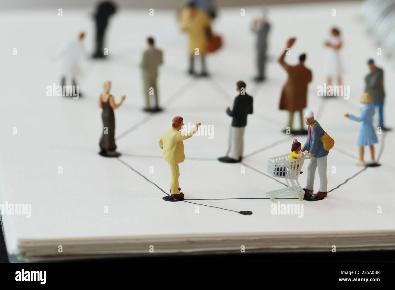 Close up di persone in miniatura con sociale schema di rete sul notebook aperto sulla scrivania di legno come i social media concept Foto Stock