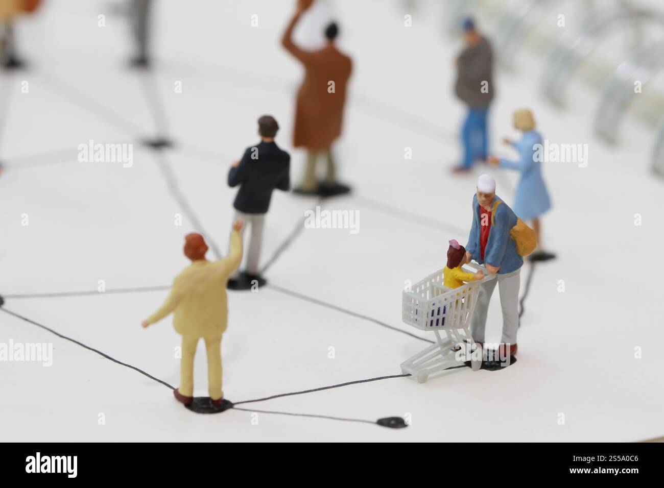 Close up di persone in miniatura con sociale schema di rete sul notebook aperto sulla scrivania di legno come i social media concept Foto Stock