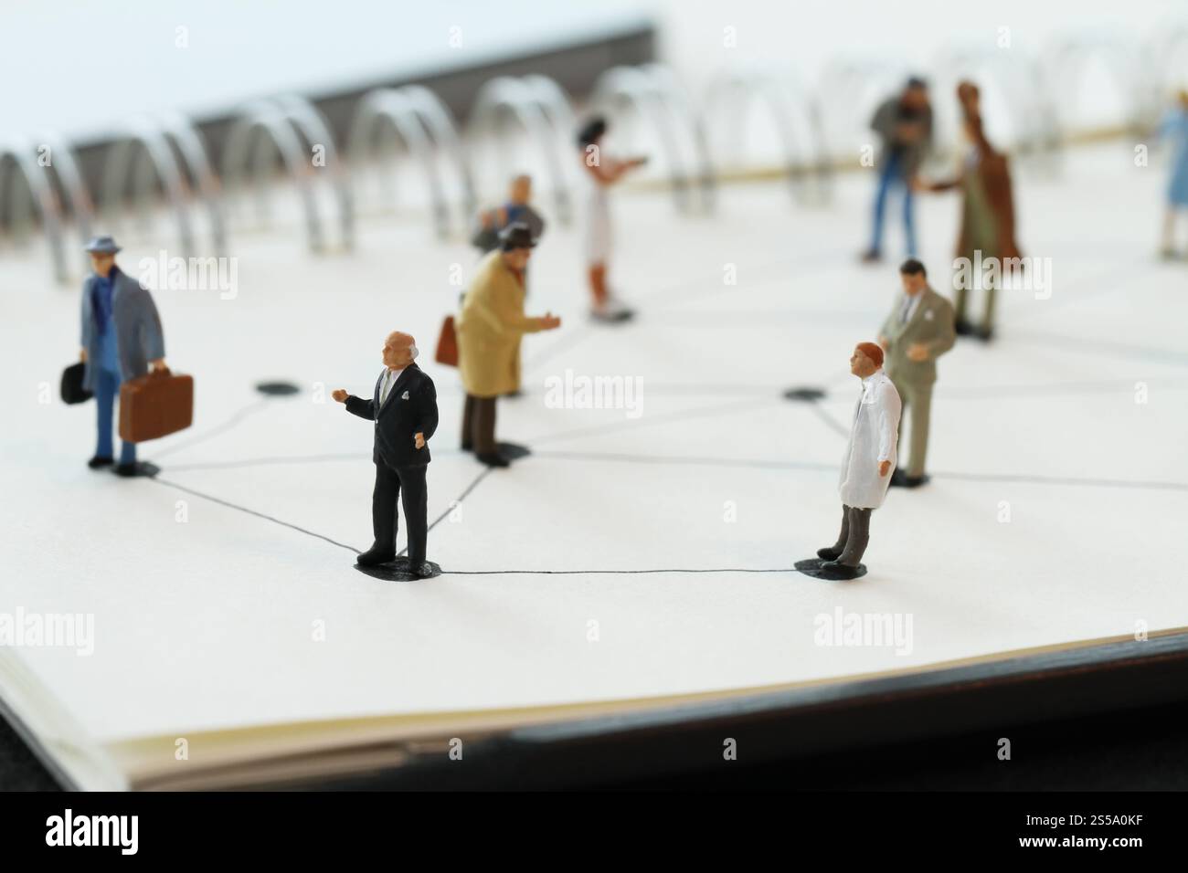 Close up di persone in miniatura con sociale schema di rete sul notebook aperto sulla scrivania di legno come i social media concept Foto Stock