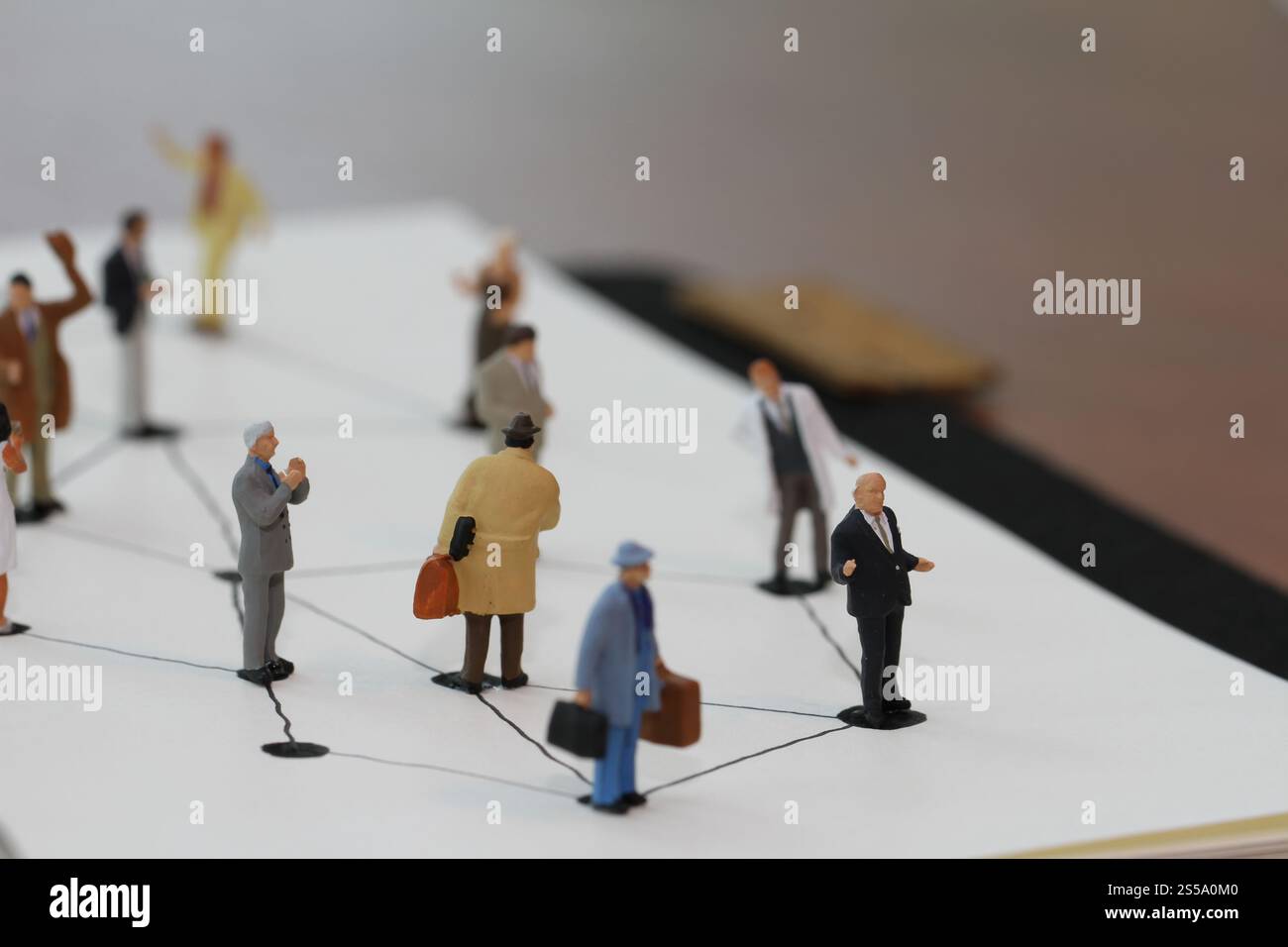 Close up di persone in miniatura con sociale schema di rete sul notebook aperto sulla scrivania di legno come i social media concept Foto Stock