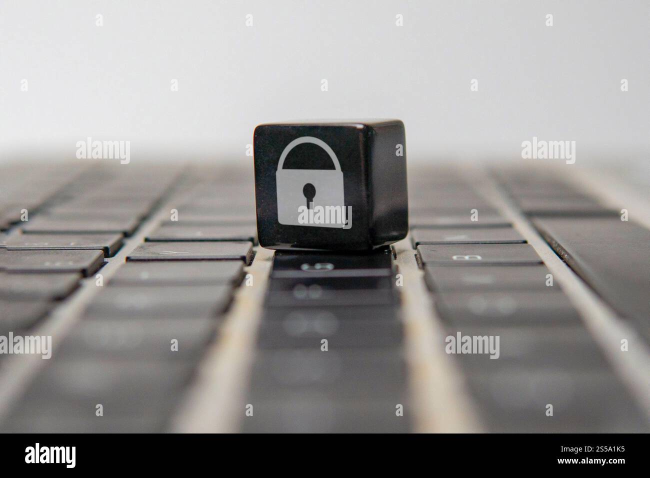 Cubo con il simbolo di un lucchetto sulla tastiera di un notebook. Concetto di sicurezza online, protezione dei dati e privacy digitale. Foto Stock