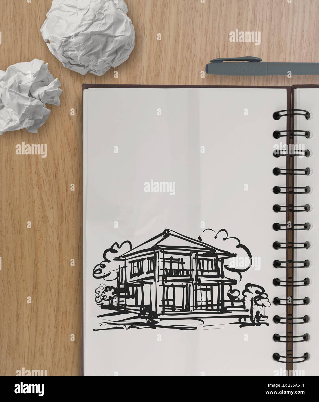 Disegno a mano casa sulla carta stropicciata con tavolo in legno come concetto Foto Stock