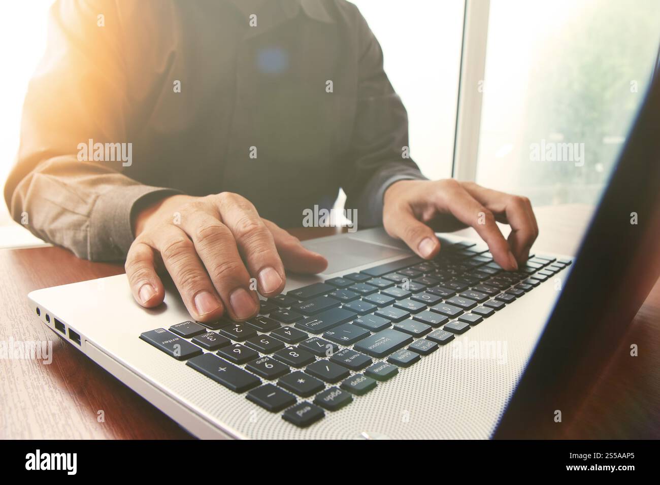 Business man mano lavorando sul computer laptop sulla scrivania di legno come concetto con cielo coperto l'effetto di esposizione Foto Stock