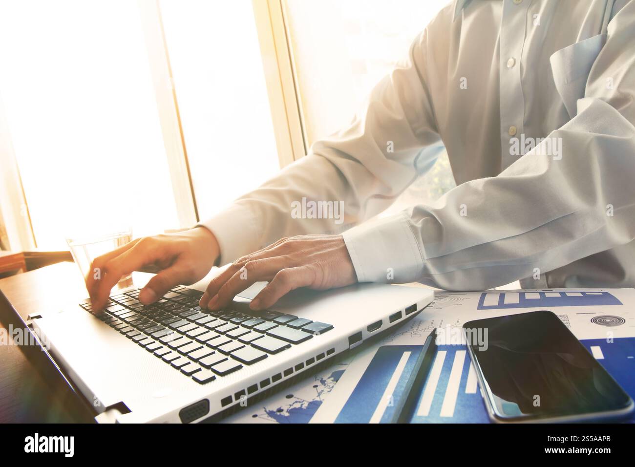 Business man mano lavorando sul computer laptop sulla scrivania di legno come concetto con cielo coperto l'effetto di esposizione Foto Stock