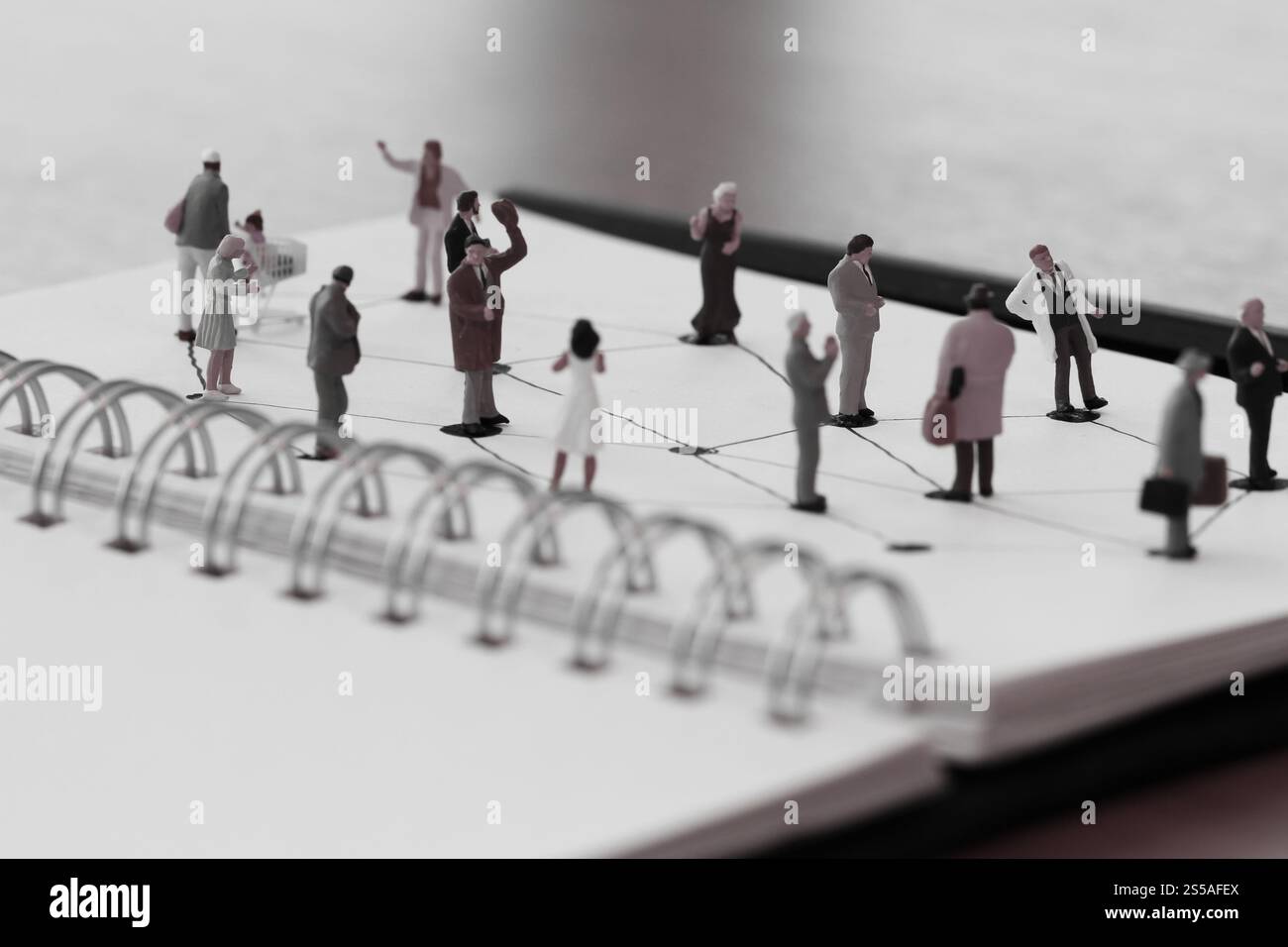 Close up di persone in miniatura con sociale schema di rete sul notebook aperto sulla scrivania di legno come i social media concept Foto Stock