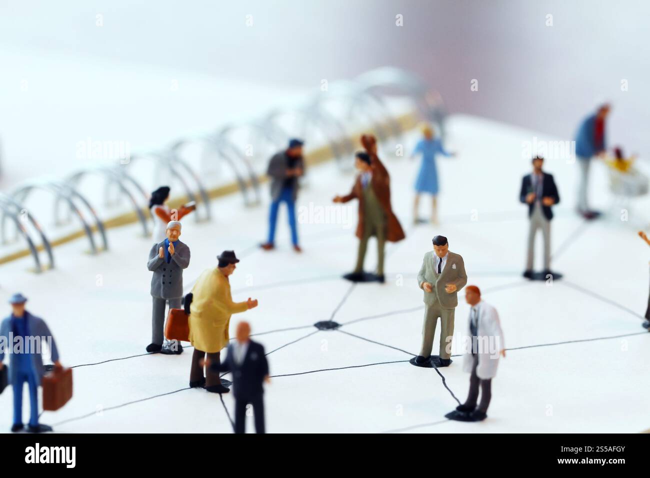 Close up di persone in miniatura con sociale schema di rete sul notebook aperto sulla scrivania di legno come i social media concept Foto Stock