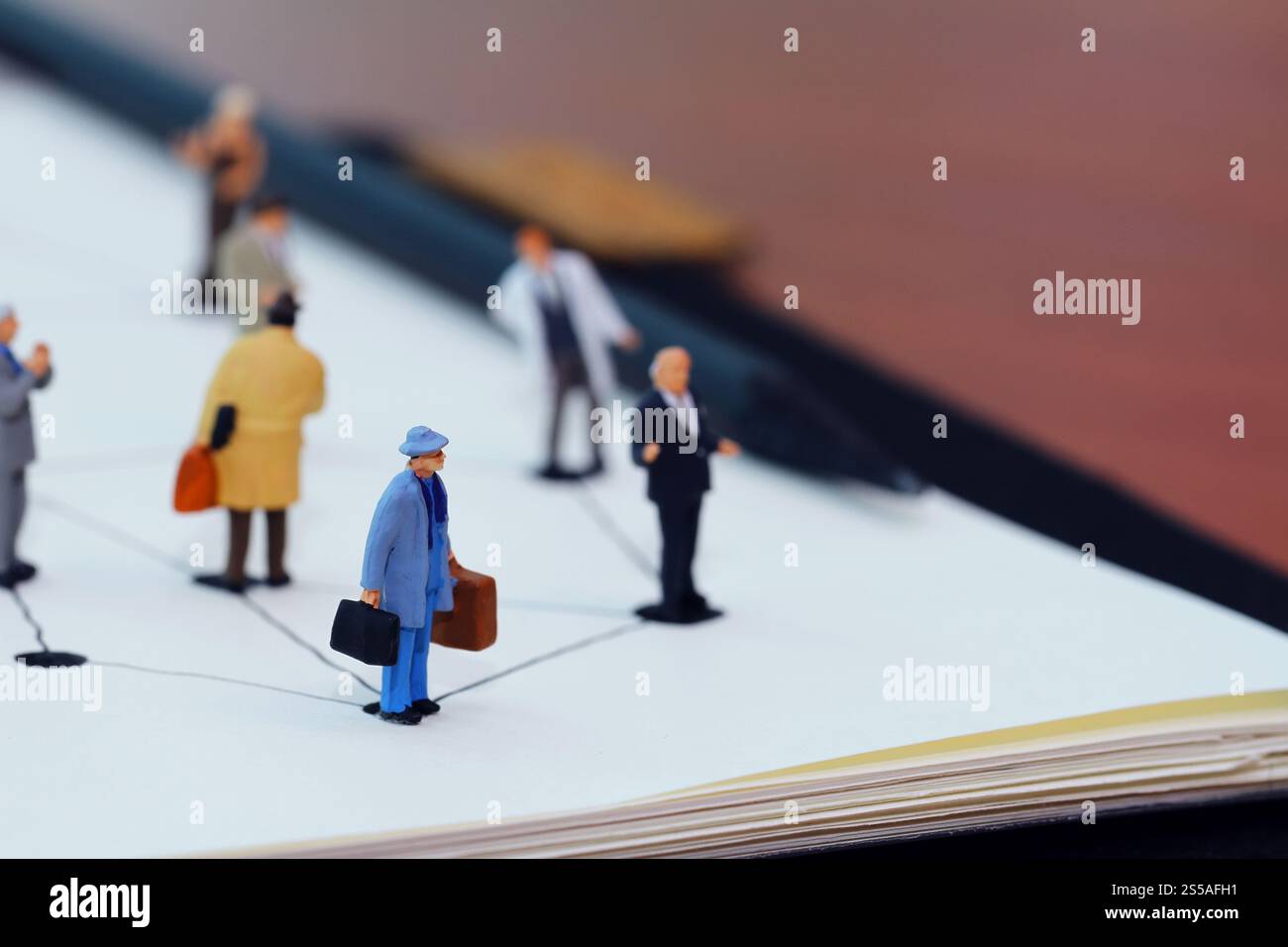 Close up di persone in miniatura con sociale schema di rete sul notebook aperto sulla scrivania di legno come i social media concept Foto Stock