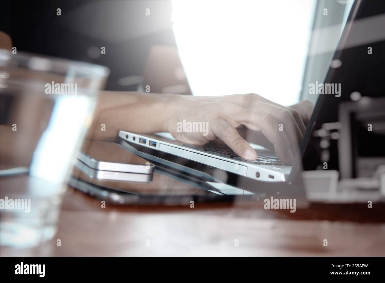 Doppia esposizione di business man mano lavorando sul computer laptop sulla scrivania di legno come concetto Foto Stock