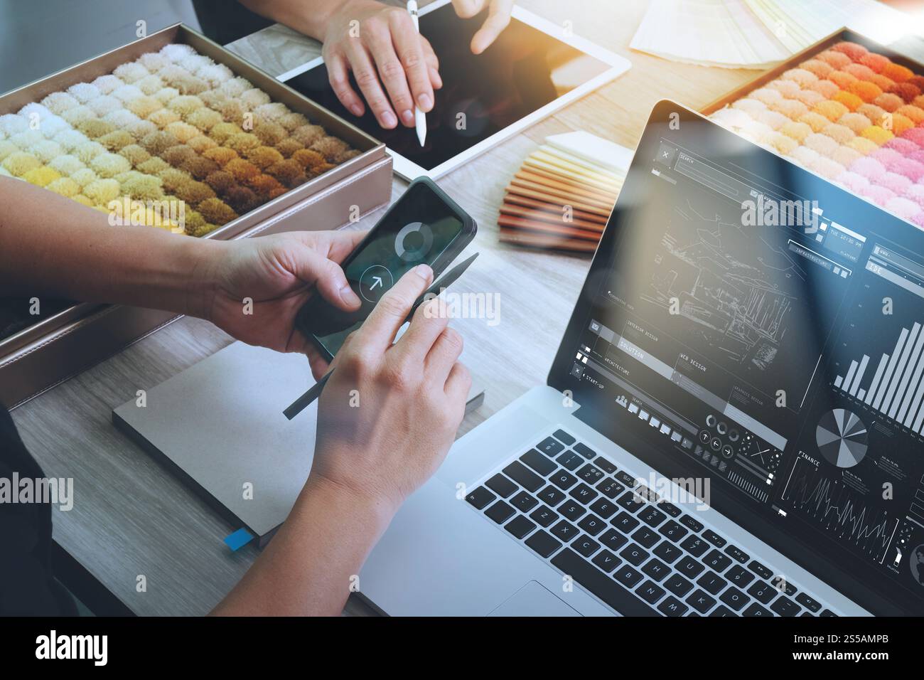 vista dall'alto di due colleghi interior designer che discutono i dati con un diagramma di progettazione sul nuovo schermo di un computer laptop e uno smartphone moderno con un esempio Foto Stock