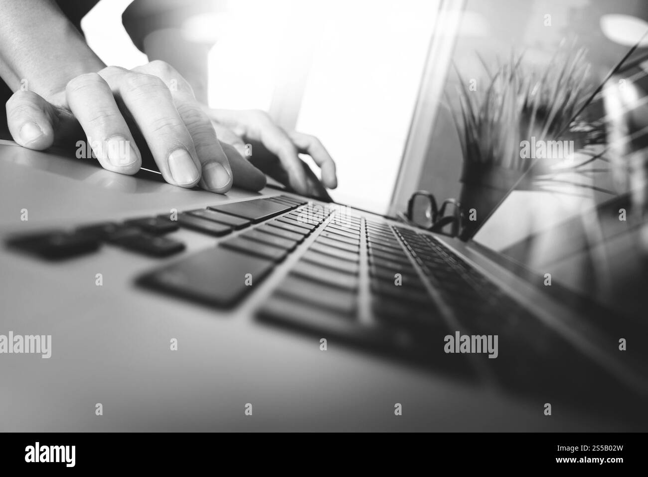 uomo d'affari che lavora a mano su un computer portatile con schermo bianco su una scrivania di legno come concetto, bianco e nero Foto Stock uomo d'affari che lavora a mano su un computer portatile con schermo bianco su una scrivania di legno come concetto, bianco e nero Foto Stock