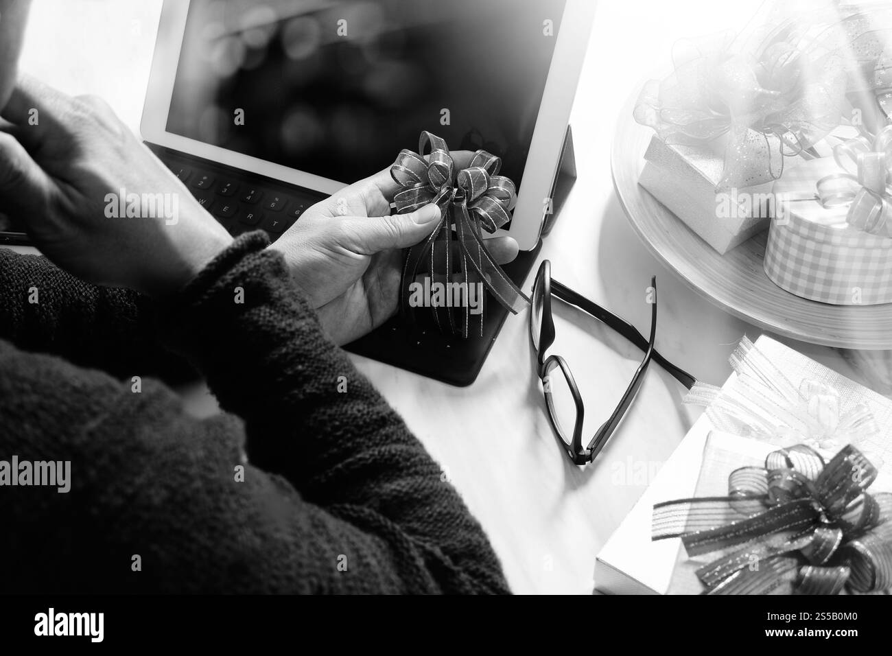 Regala una selezione creativa e una mano con un regalo. Consegna regalo, sorpresa, docking per tablet, tastiera intelligente, smartphone sulla scrivania Mable, filtro Foto Stock
