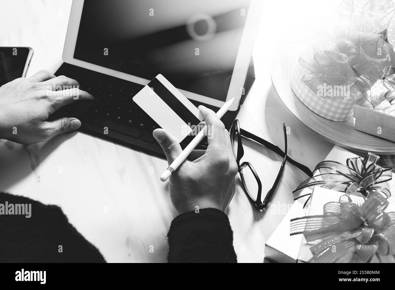 Regalo per mano creativa con carta di credito e mano con regalo. Consegna regalo, sorpresa, docking per tablet, tastiera intelligente, smartphone su Mable Foto Stock