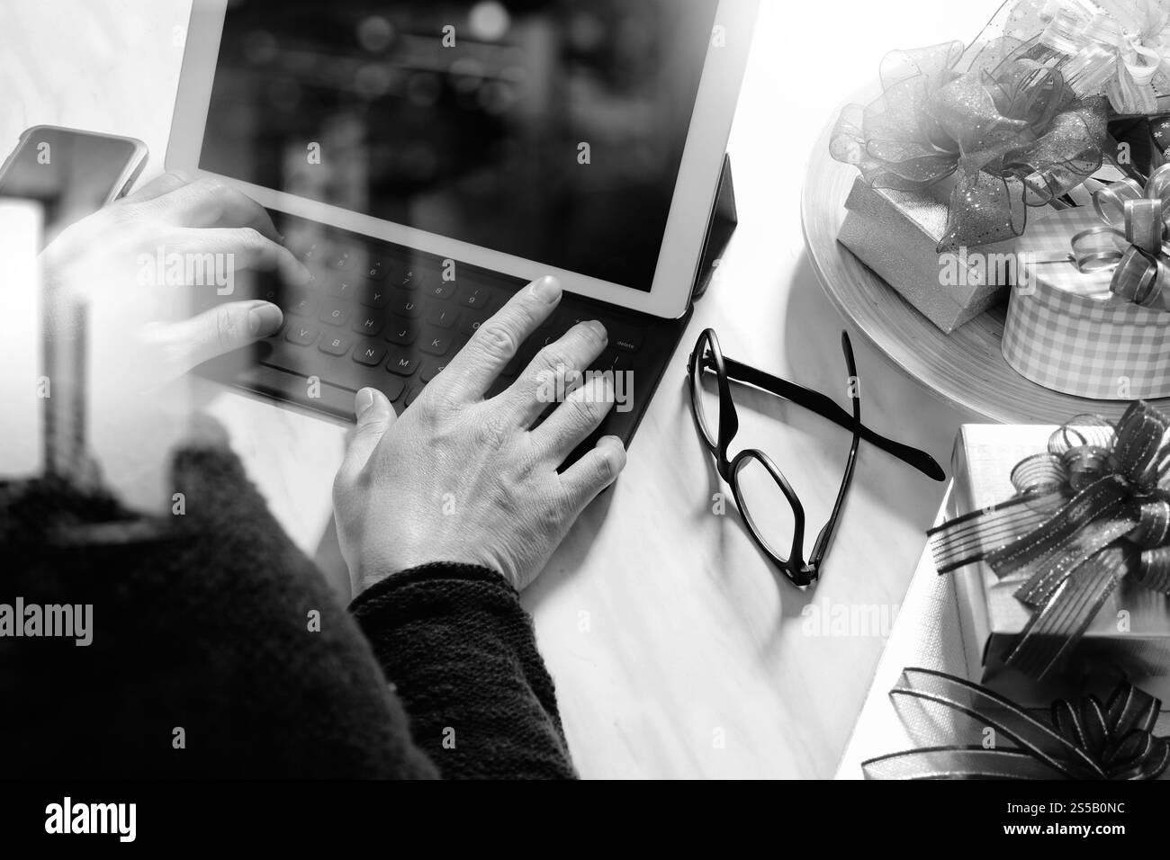 Regala una mano creativa con la digitazione e una mano con il regalo. Consegna regalo, sorpresa, docking per tablet, tastiera intelligente, smartphone su Mable Foto Stock