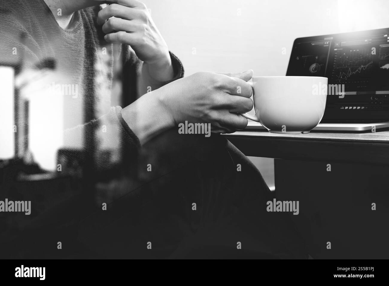 Imprenditore di successo mano utilizzando smart phone,digitale compressa docking tastiera intelligente,tazza di caffè sulla scrivania in legno,bianco nero Foto Stock