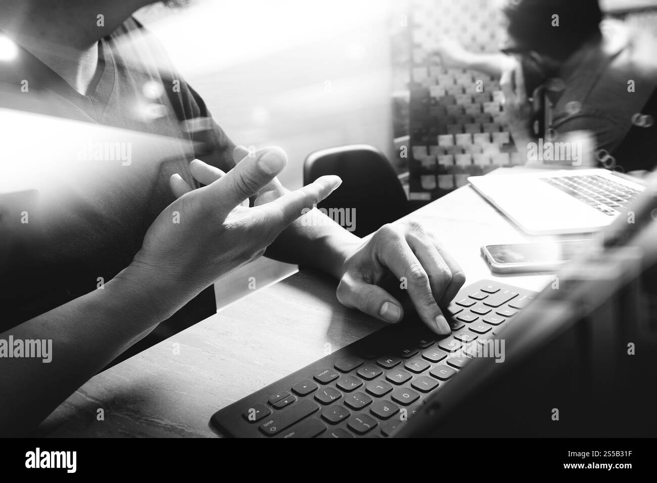 Processo di coworking, team di imprenditori che lavora in un ufficio creativo. utilizzo della base docking digitale per tablet e di un computer portatile con smartphone su marmo Foto Stock