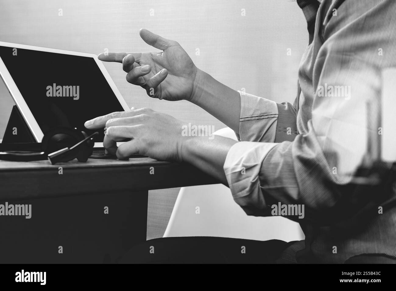 Business man utilizzando cuffie VOIP con tavoletta digitale computer docking tastiera intelligente, il concetto di comunicazione, il supporto it,sulla scrivania di legno,bianco nero Foto Stock