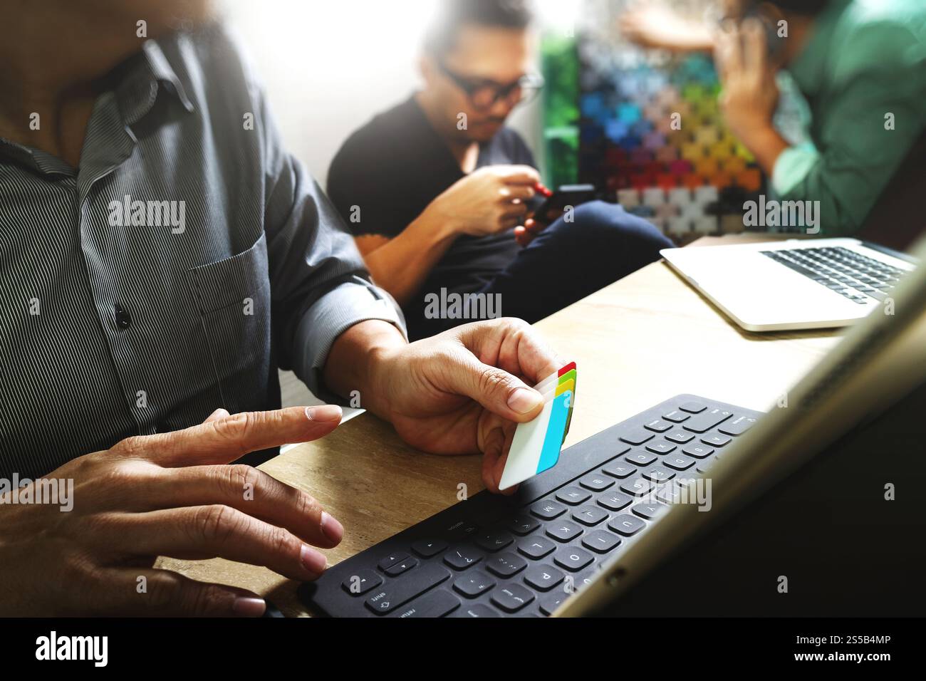 Processo di coworking, team di imprenditori che lavora in un ufficio creativo. utilizzo della base docking digitale per tablet e di un computer portatile con smartphone su marmo Foto Stock