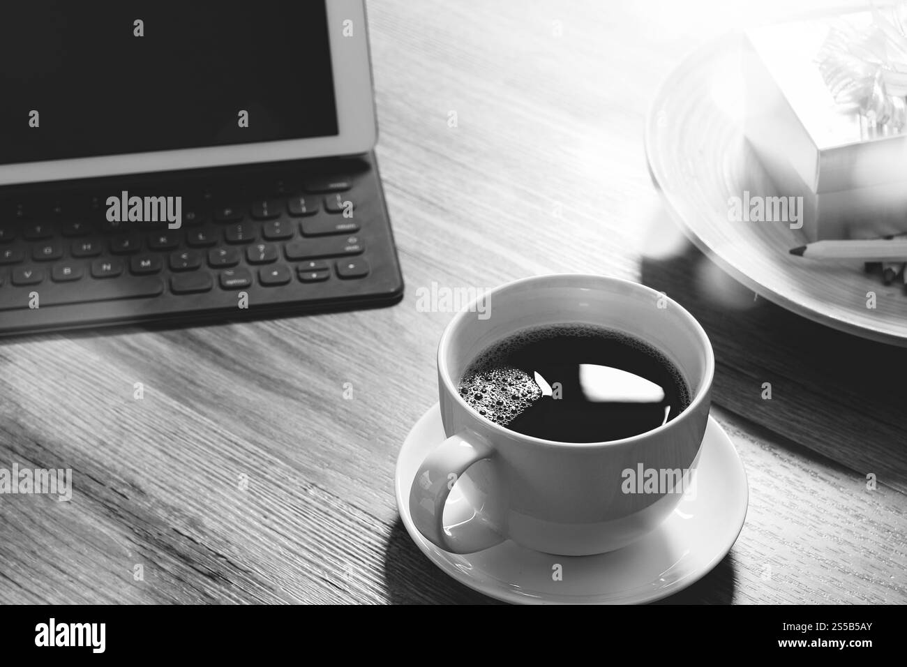 Tazza di caffè e il tavolo digitale dock tastiera intelligente,gold confezione regalo e legno tondo vassoio,matita colorata sul tavolo di legno,l'effetto filtro,bianco nero Foto Stock