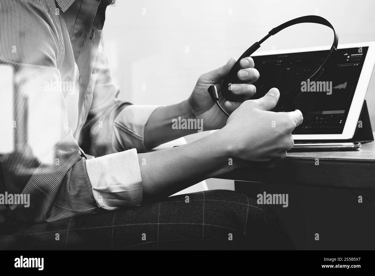 Business man utilizzando cuffie VOIP con tavoletta digitale computer docking tastiera intelligente, il concetto di comunicazione, il supporto it,sulla scrivania di legno,bianco nero Foto Stock
