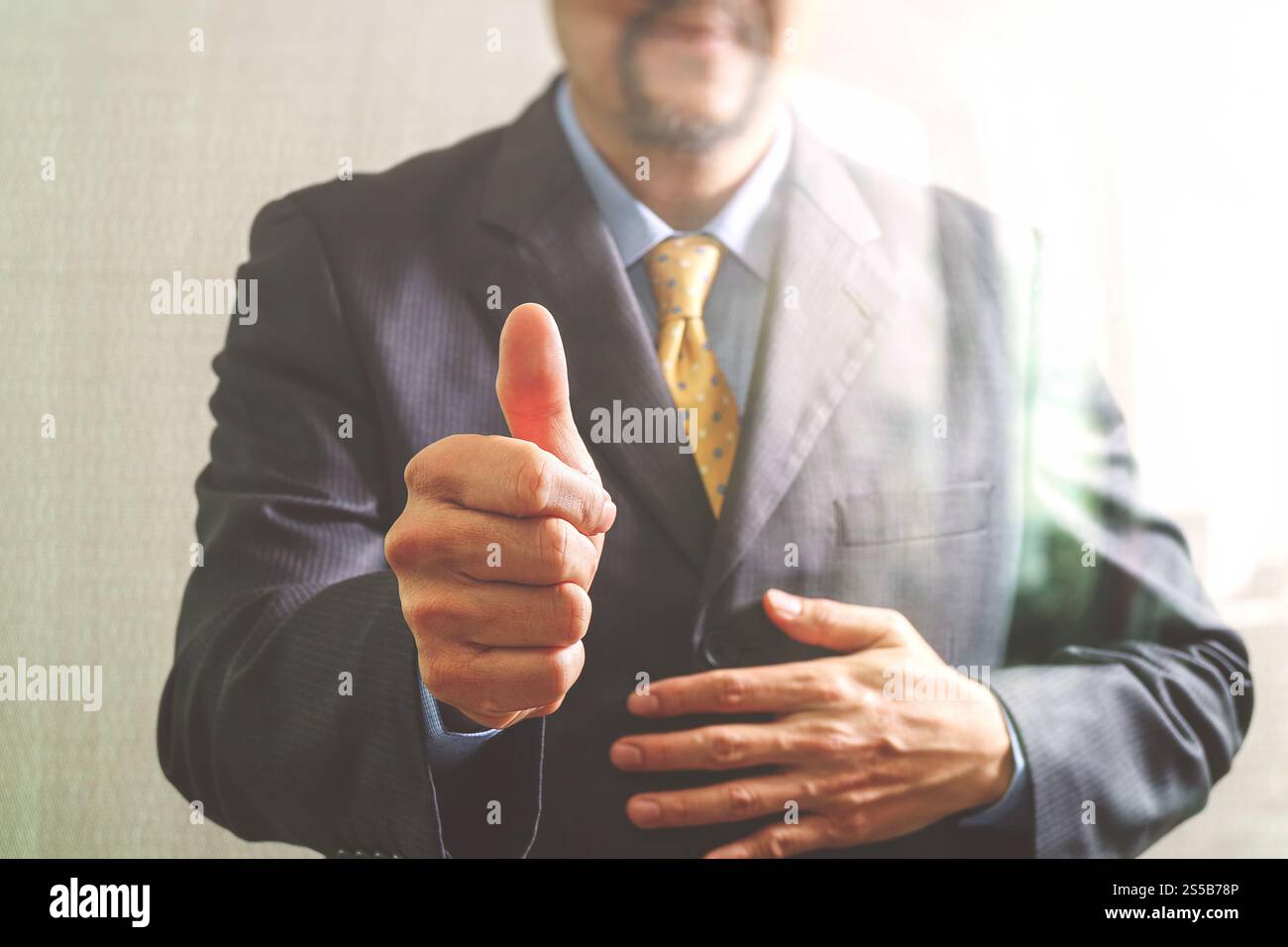 Uomo d'affari con il pollice in alto vista frontale, senza testa. Concetto di lavorare in un ufficio.effetto filtro Foto Stock