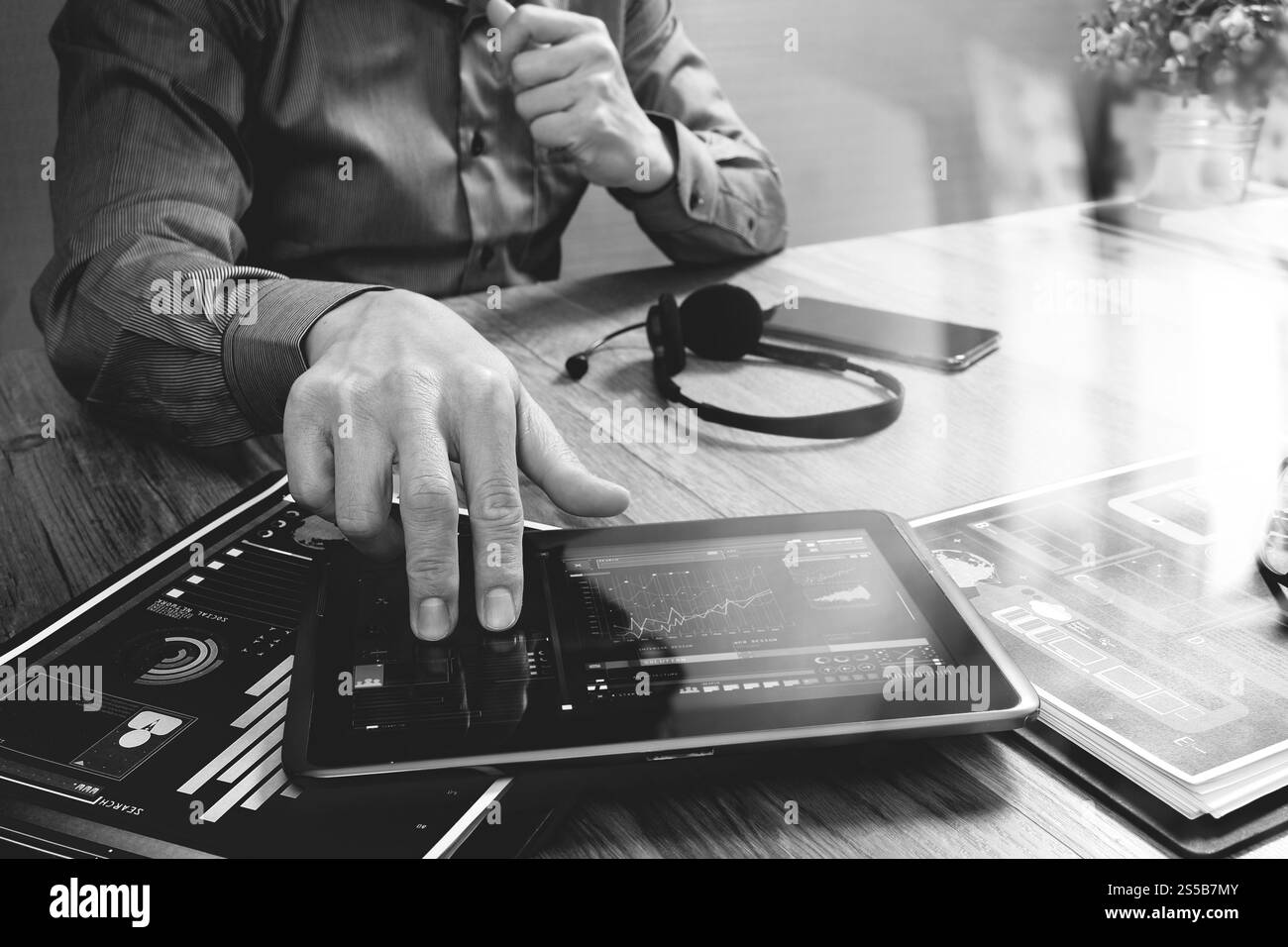 Uomo d'affari che utilizza una cuffia VoIP con un tablet digitale, documenti, comunicazioni concettuali, supporto IT, call center e assistenza clienti Foto Stock