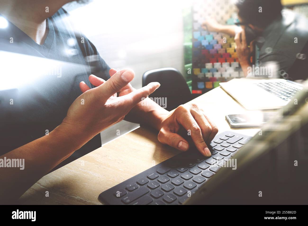 Processo di coworking, team di imprenditori che lavora in un ufficio creativo. utilizzo della base docking digitale per tablet e di un computer portatile con smartphone su marmo Foto Stock