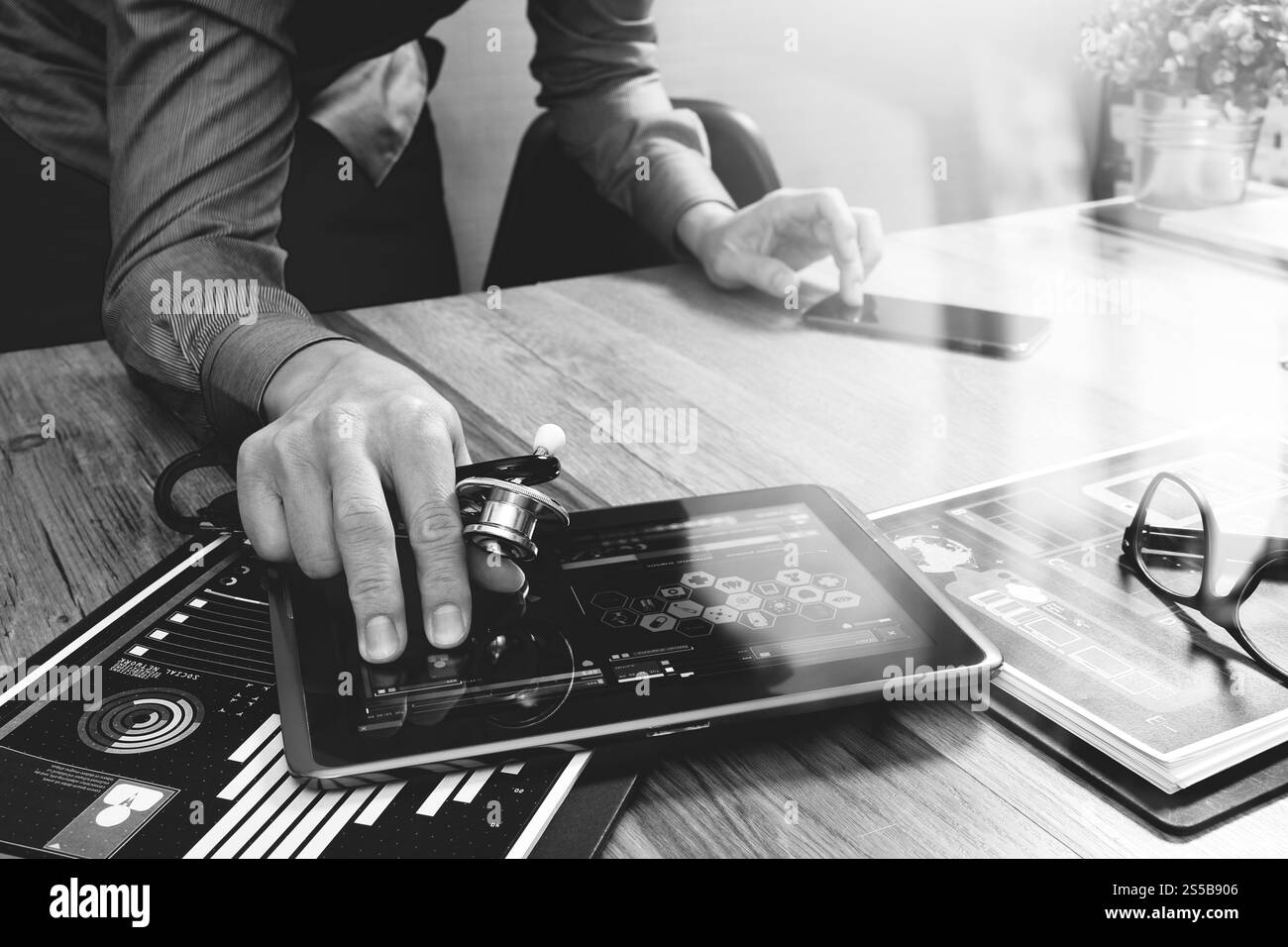 Medico che lavorano con tavoletta digitale computer con smart phone in area di lavoro medico ufficio e video conferenza come concetto,bianco nero Foto Stock