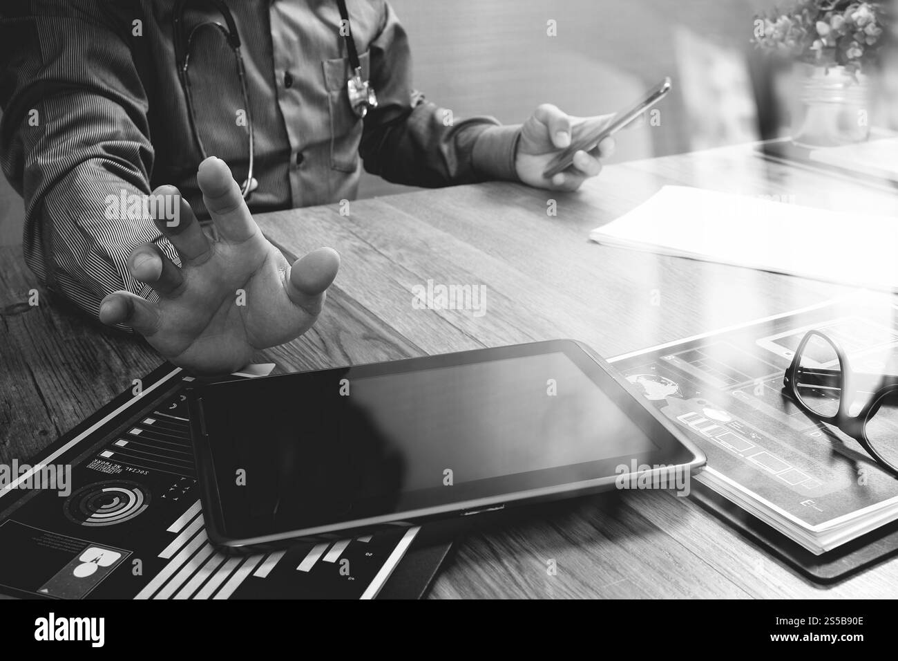 Medico che lavorano con tavoletta digitale computer con smart phone in area di lavoro medico ufficio e video conferenza come concetto,bianco nero Foto Stock