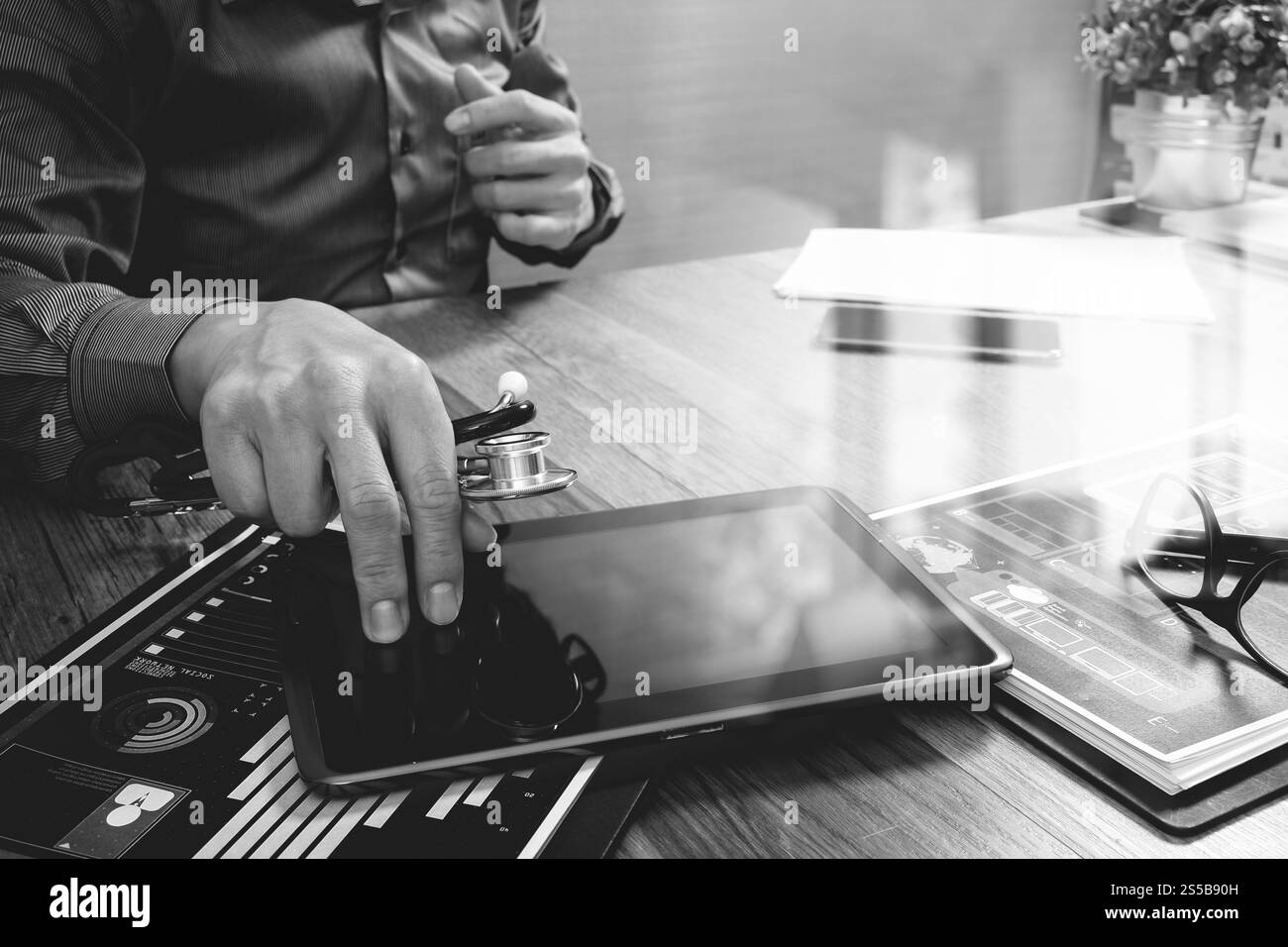 Medico che lavorano con tavoletta digitale computer con smart phone in area di lavoro medico ufficio e video conferenza come concetto,bianco nero Foto Stock