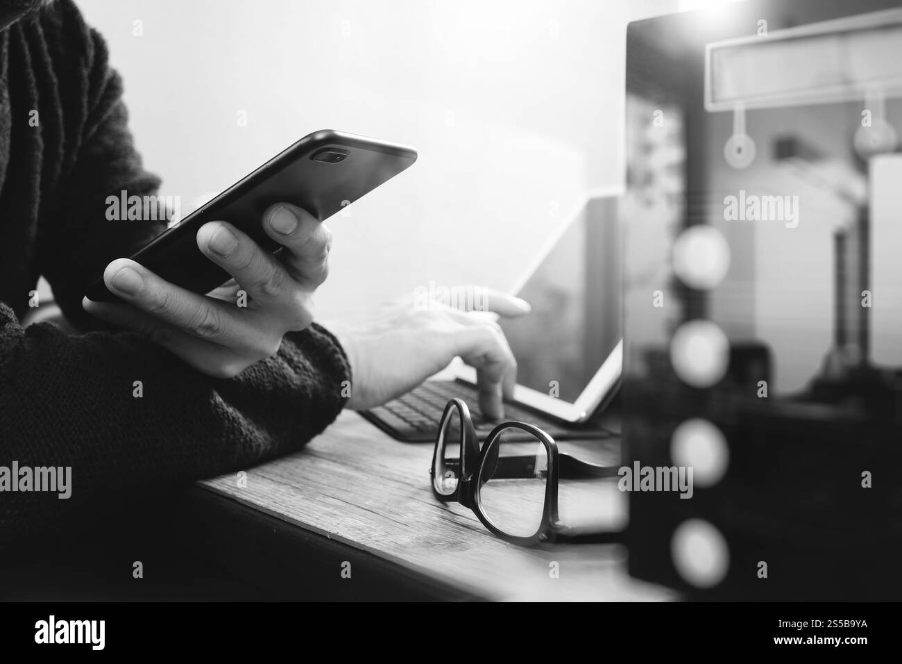 uomo d'affari che usa smartphone, pagamenti mobili online, omni channel, tablet digitale docking tastiera computer, server compatto su legno Foto Stock