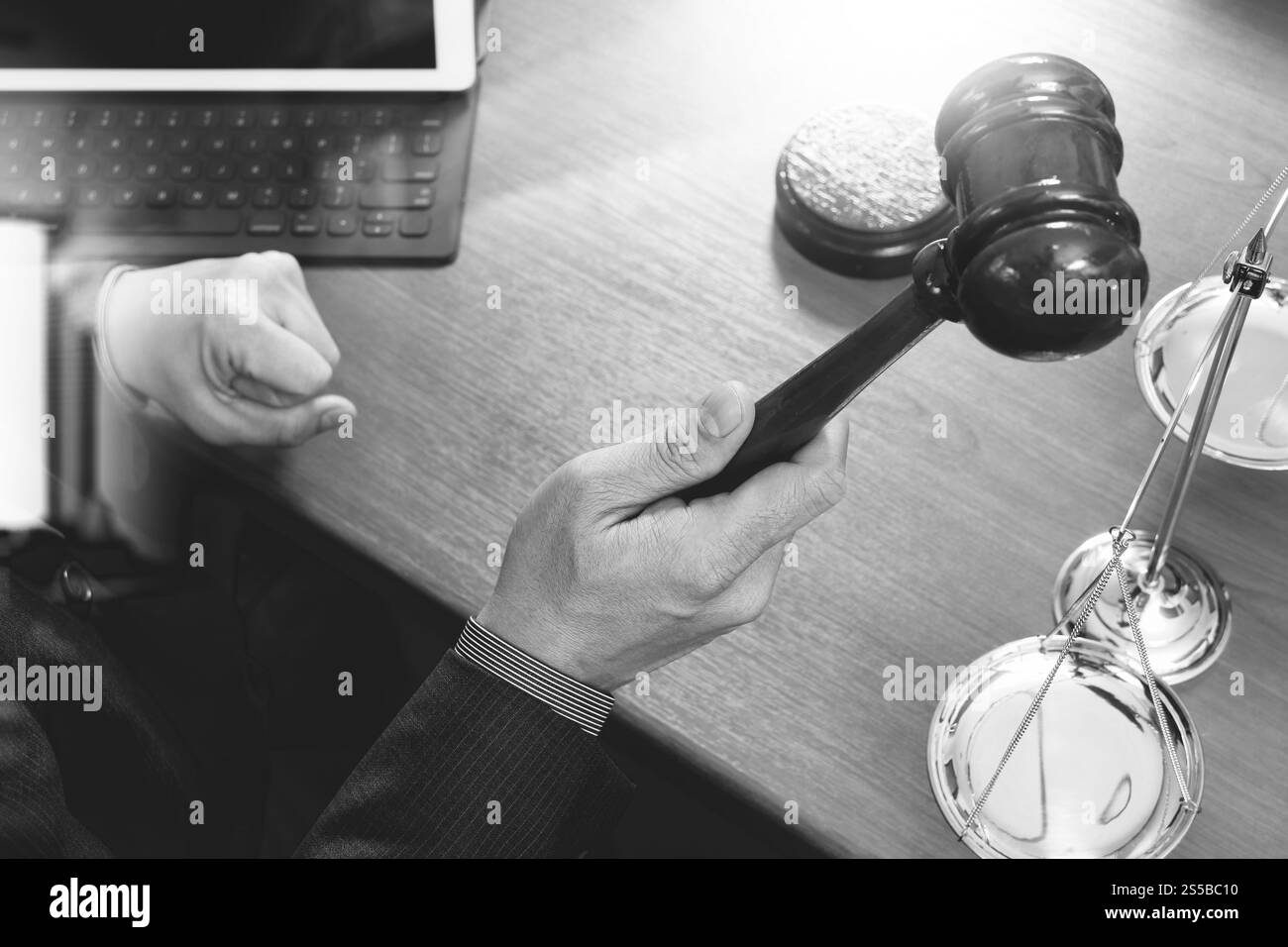 concetto di giustizia e diritto. Giudice maschile in un'aula di tribunale con il martelletto, che lavora con smartphone, tablet digitale, tastiera, bilancia in ottone, ON Foto Stock
