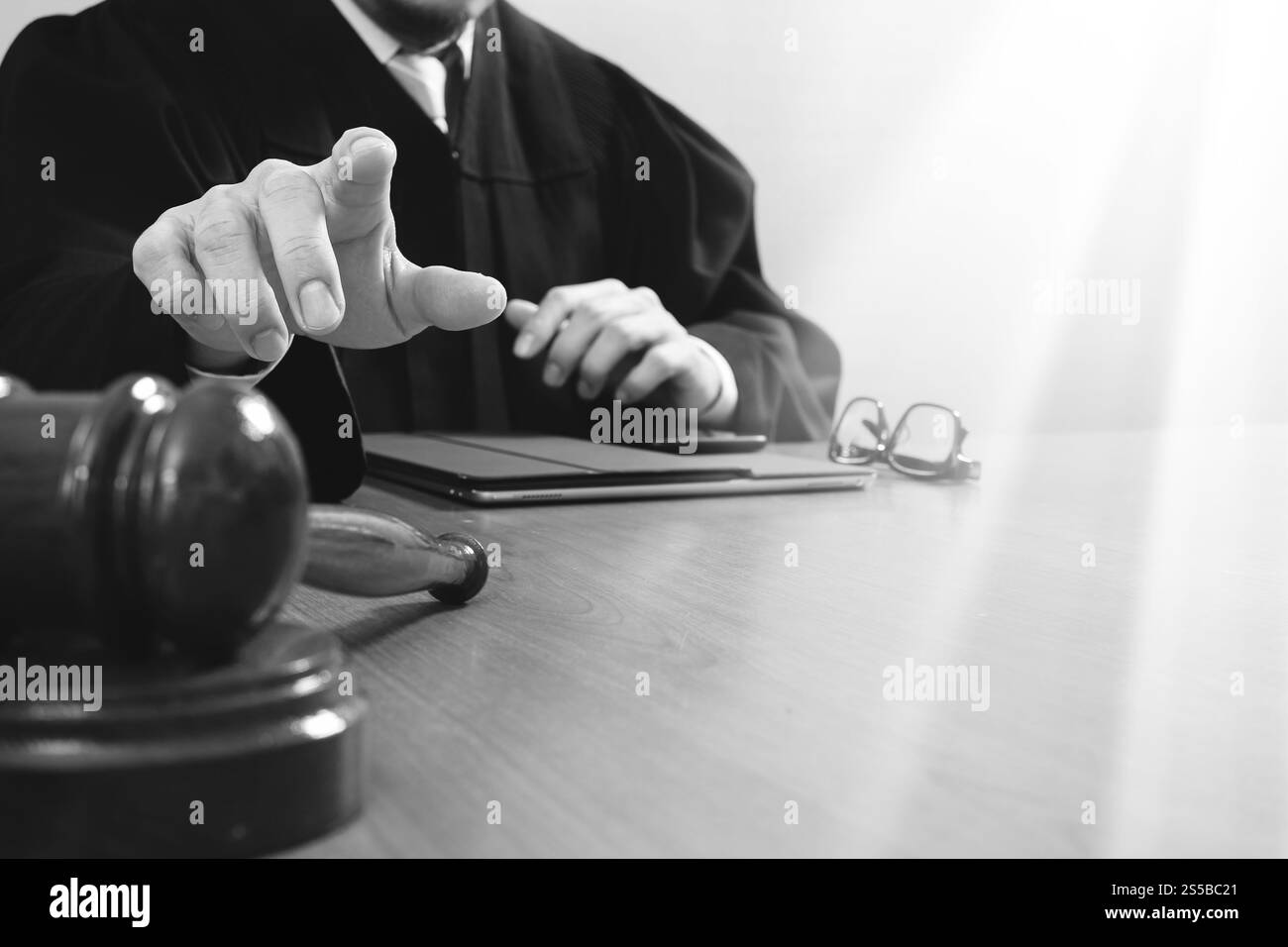 La giustizia e la nozione di diritto.Giudice maschi nelle aule di un tribunale con il martello,lavora con smart phone,digital computer tablet tastiera docking,occhiali,su legno Foto Stock