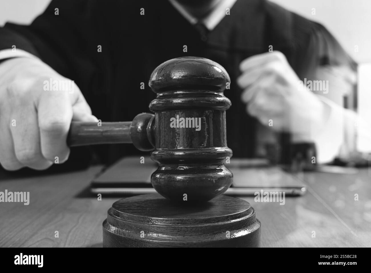 La giustizia e la nozione di diritto.Giudice maschi nelle aule di un tribunale con il martello,lavora con smart phone,digital computer tablet tastiera docking,occhiali,su legno Foto Stock