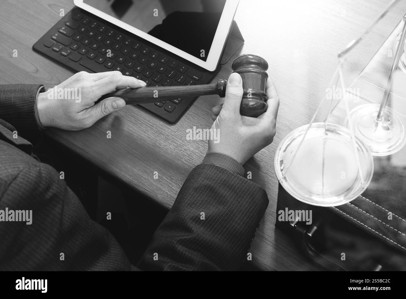 concetto di giustizia e diritto. Giudice maschile in un'aula di tribunale con il martelletto, che lavora con smartphone, tablet digitale, tastiera, bilancia in ottone, ON Foto Stock