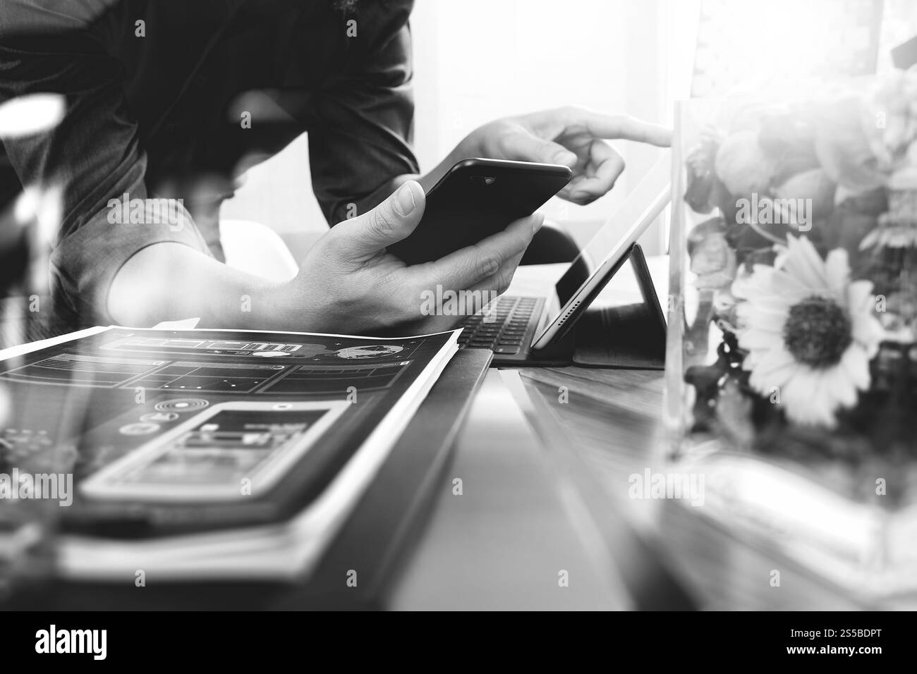 Uomo che utilizza la cuffia VoIP con smartphone e tablet digitale come call center e help desk del servizio clienti e fiori di vaso su legno Foto Stock