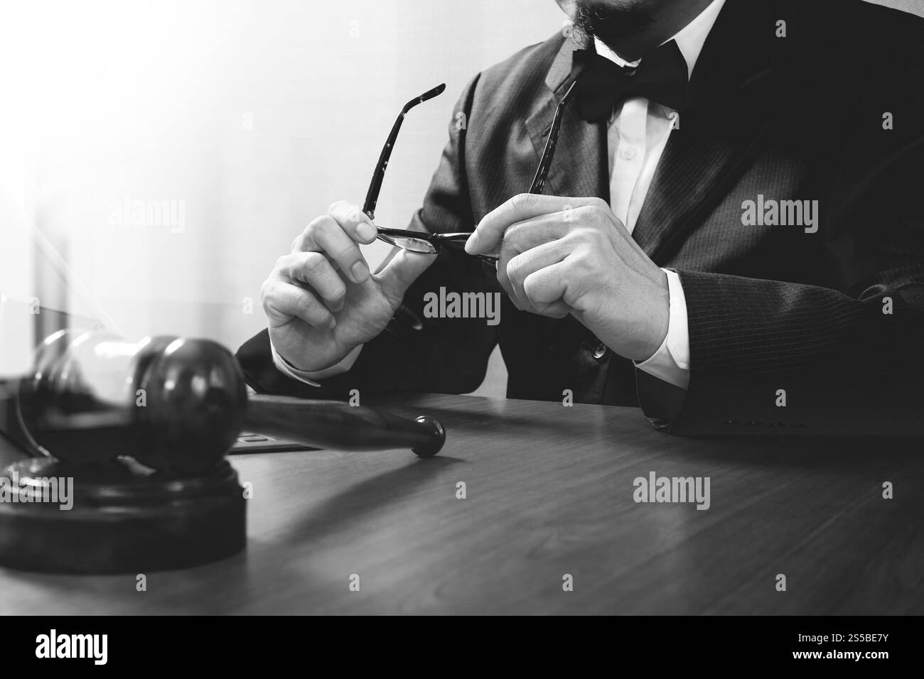 La giustizia e la nozione di diritto.Giudice maschi nelle aule di un tribunale con il martello,lavora con smart phone,digital computer tablet tastiera docking,occhiali,su legno Foto Stock