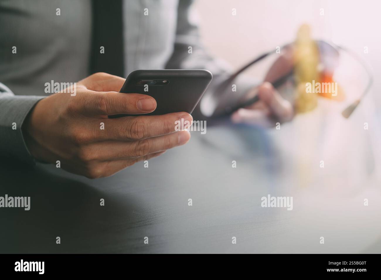 Imprenditore tramite VOIP auricolare con il telefono cellulare e il concetto di comunicazione centro di chiamata sulla scrivania in legno Foto Stock
