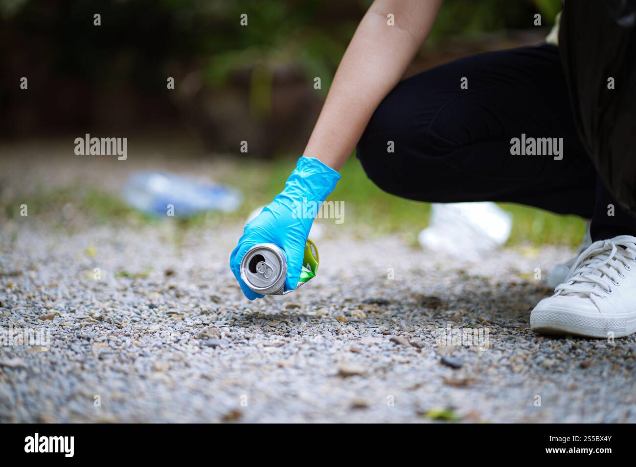 Donatrice volontaria che tiene a mano il sacchetto nero della spazzatura e la spazzatura della bottiglia di plastica per il riciclaggio per la pulizia nel parco volontariato concetto di riutilizzo e Foto Stock
