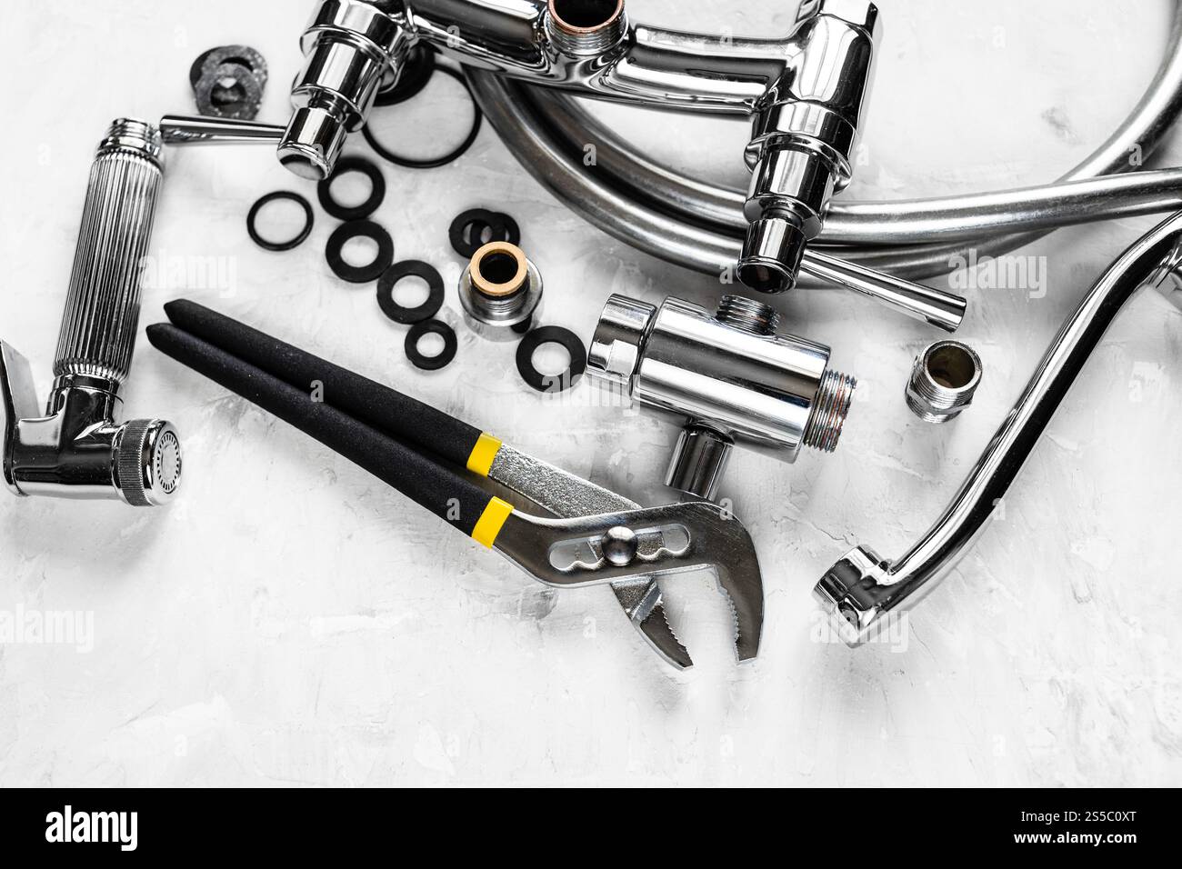 vista dall'alto della chiave e della valvola del rubinetto della doccia smontata sul pannello di calcestruzzo Foto Stock